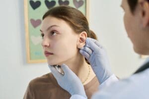 Plastic surgeon performing torn earlobe repair in Richmond to restore natural appearance